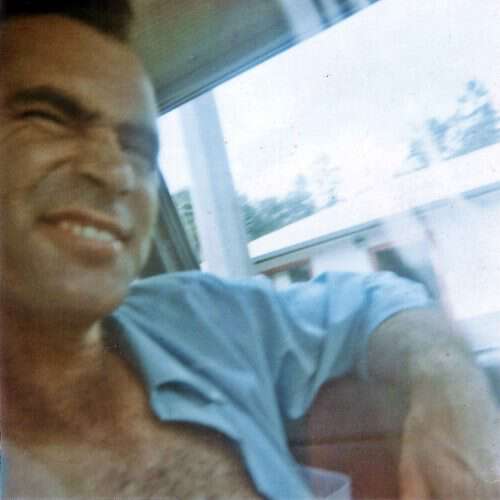 man sitting by window smiling