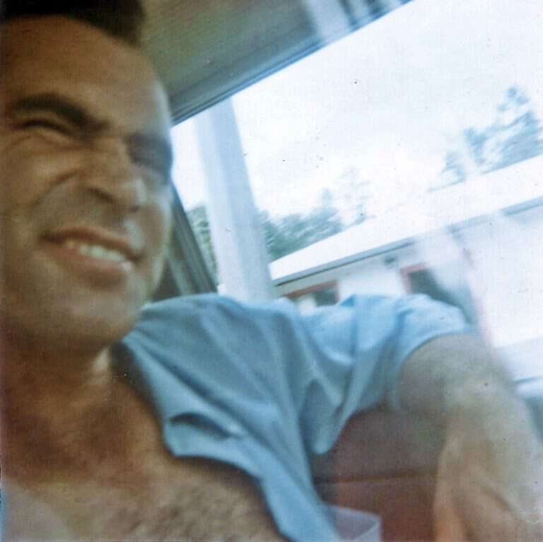 man sitting by window smiling
