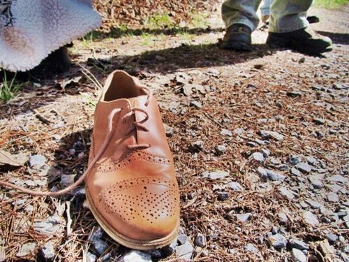 shoe sitting on gravel road