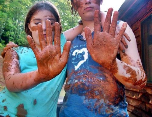 girls with muddy hands