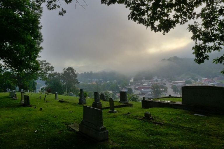 grave yard with mountains covered in fog in background