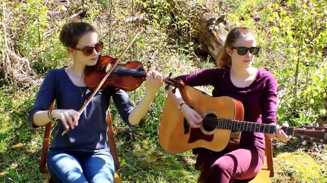 two girls sitting outside with fiddle and guitar