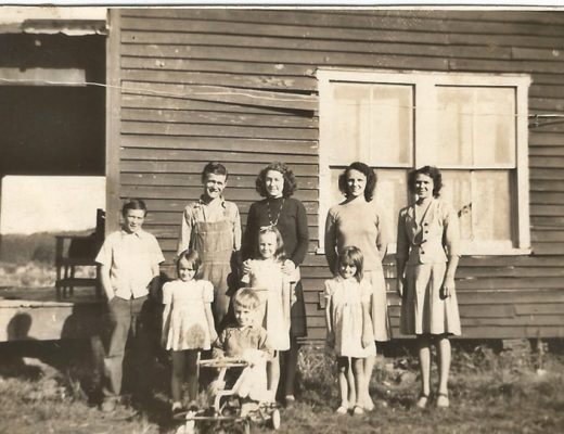 old picture of family standing by house