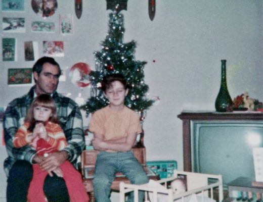 man girl and boy sitting in front of small christmas tree in appalachia