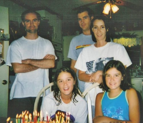 family sitting at table with birthday cake