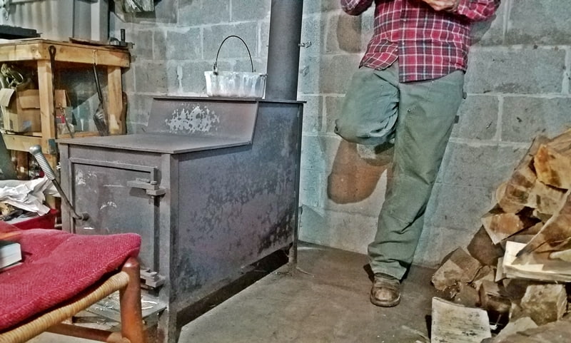 man standing by woodstove