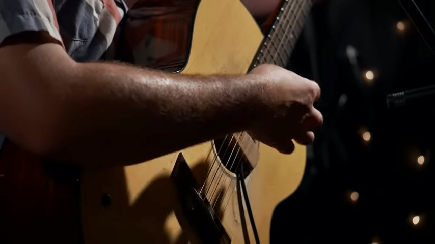man's arm playing guitar