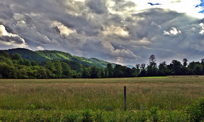 mountains surrounded by grass and cloudy skies