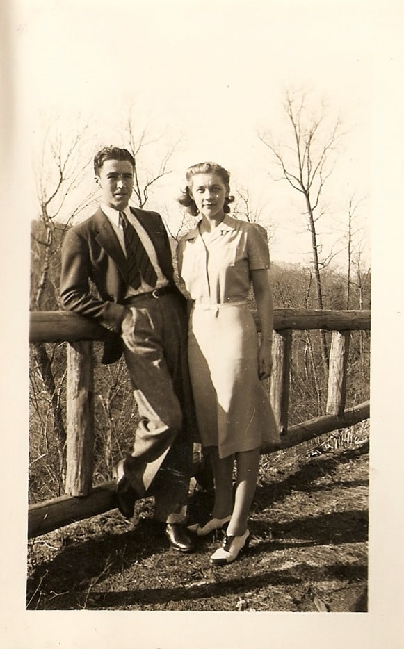 old picture of man and woman standing by fence