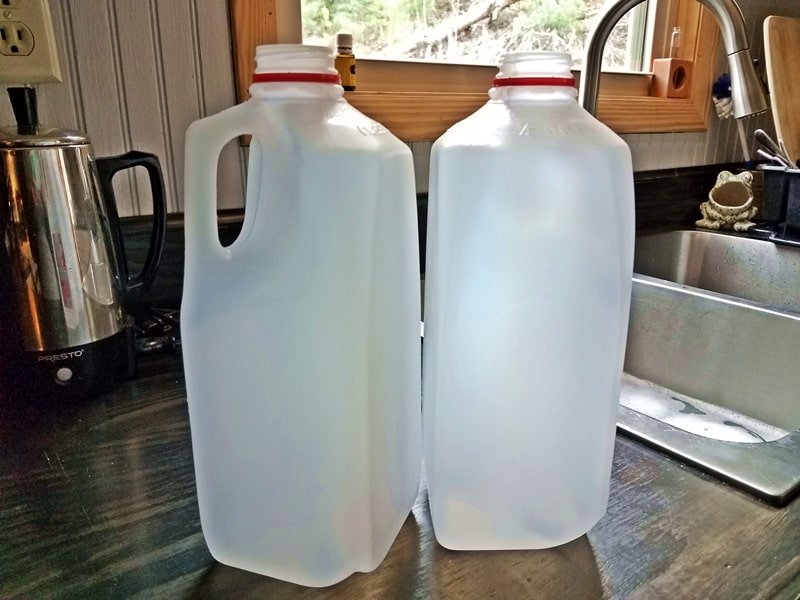 empty milk jugs by sink