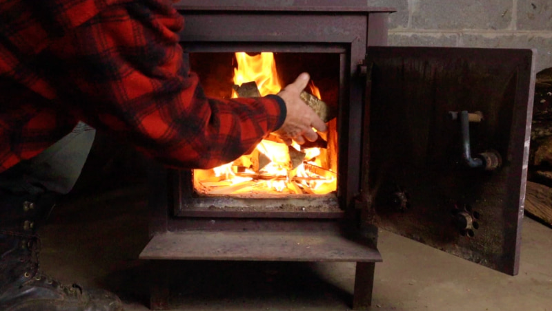 putting wood in stove