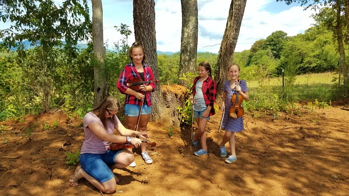 Chitter helping girls with fiddles