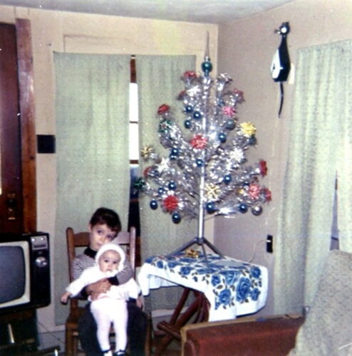 boy holding girl with Christmas tree