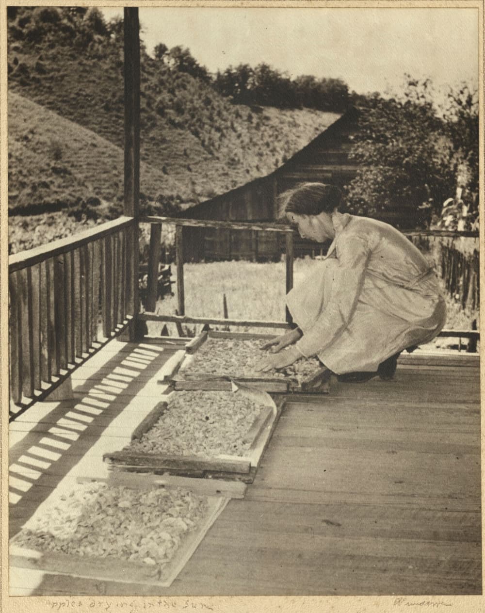 woman drying apples on porch