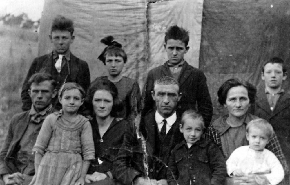 Old photo of a family in front of quilts
