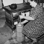 woman churning butter by stove