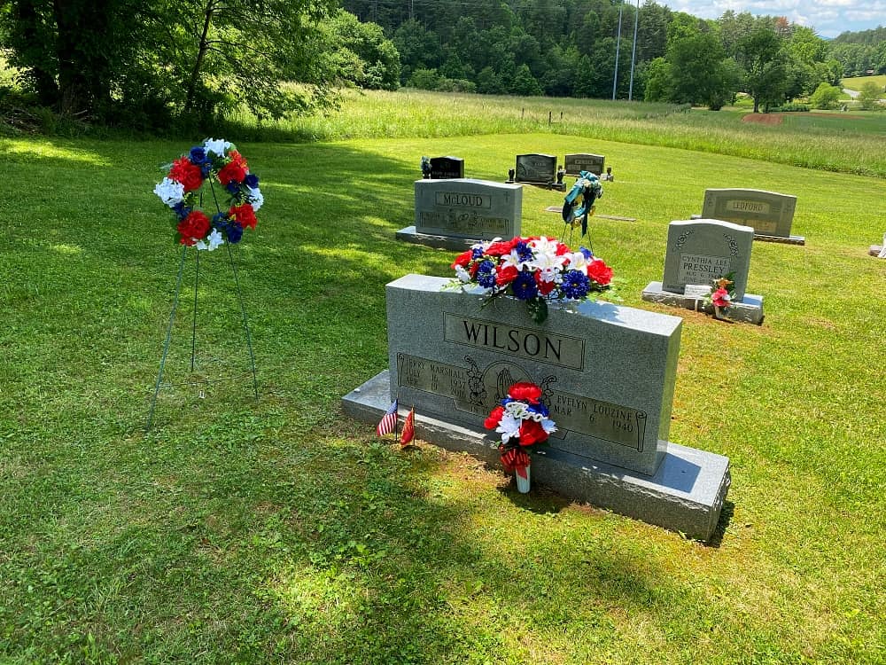 grave stone decorated with red white and blue flowers