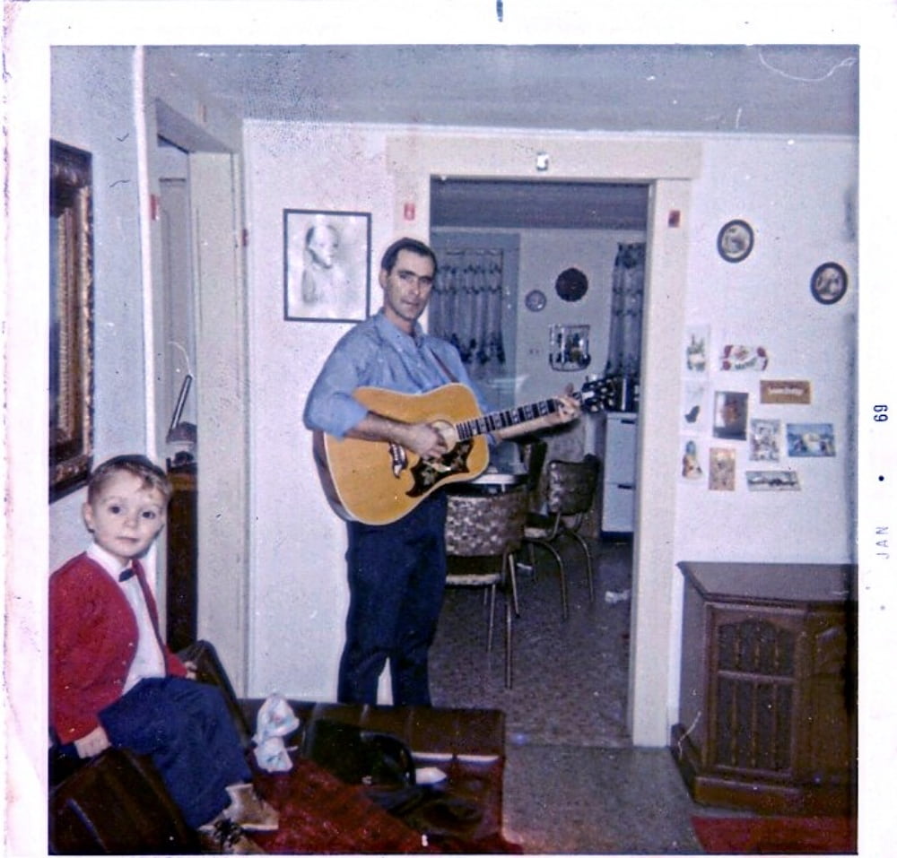 Man with guitar and small boy