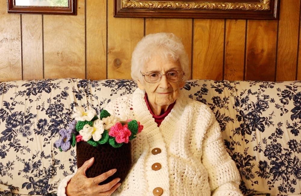 elderly woman holding flowers