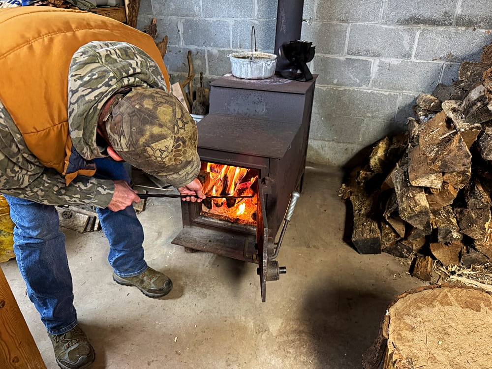 Man building fire in woodstove