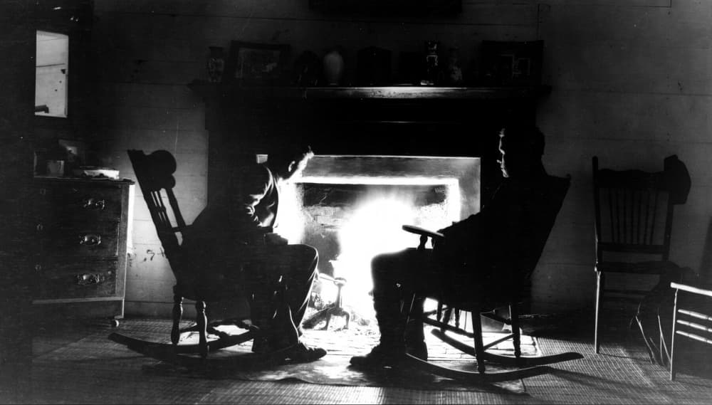2 men sitting by fireplace