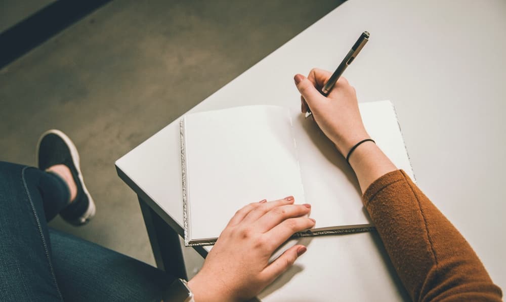 girl sitting at table writing