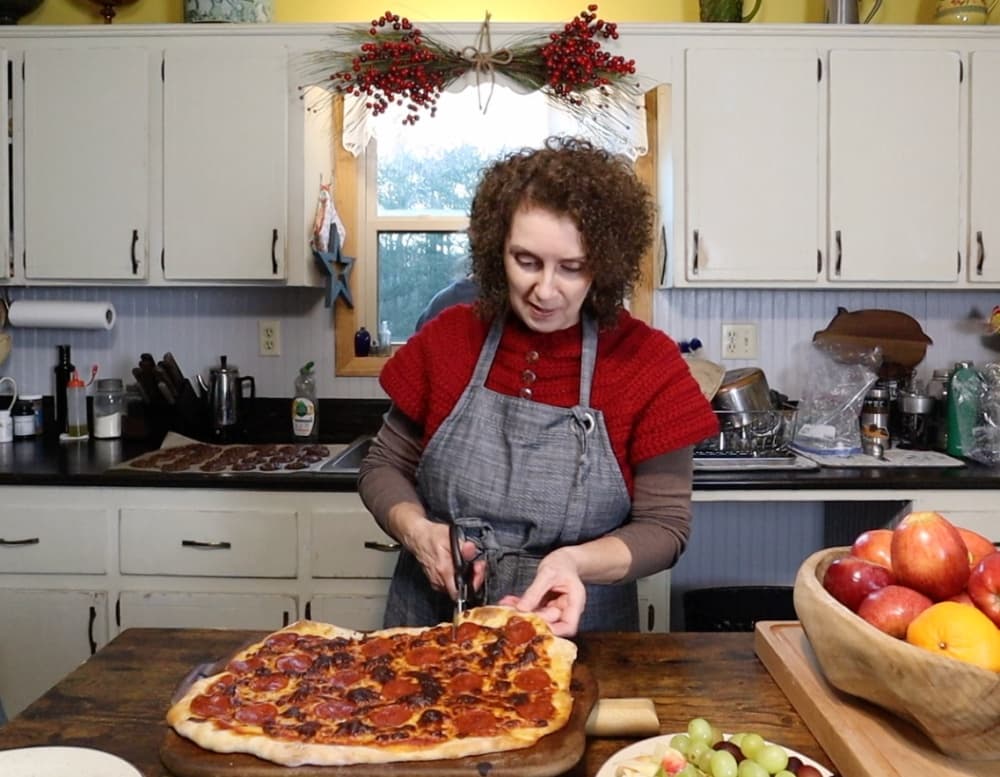 woman cutting pizza