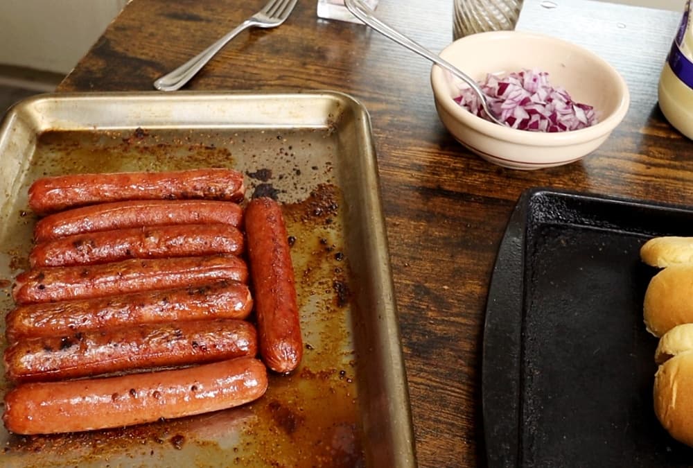 hotdogs, buns, and diced onions on table