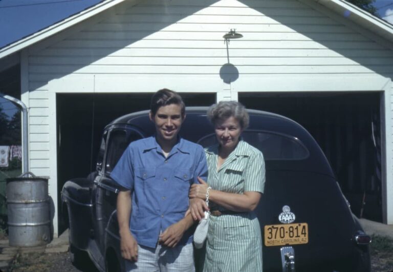 Boy and woman by old car