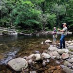 men fishing in creek