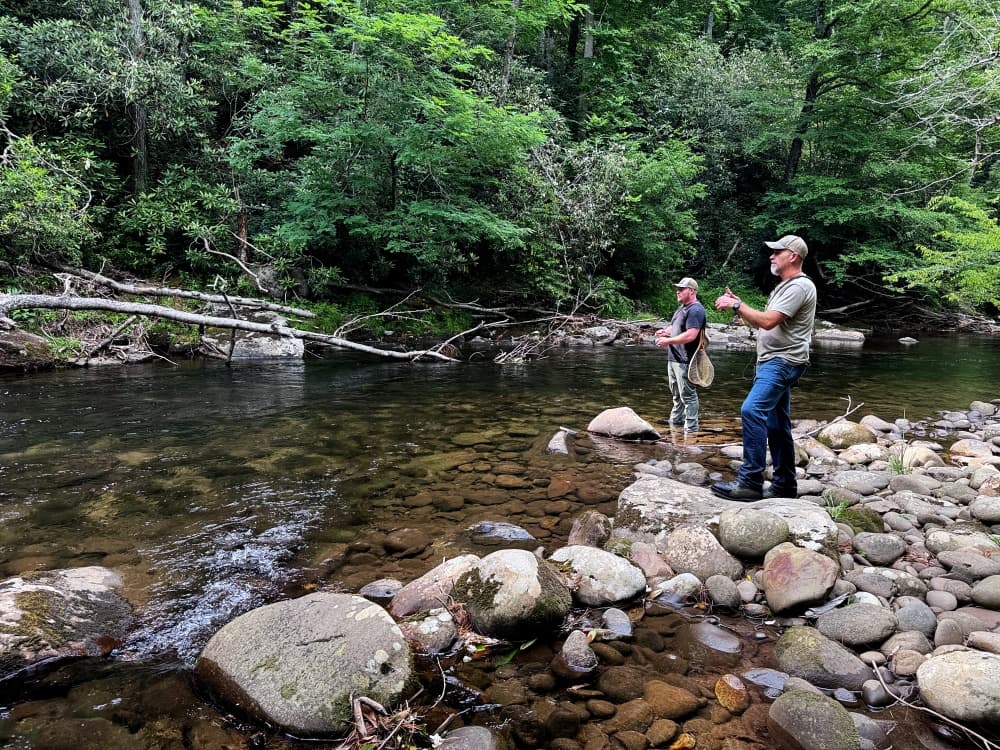 men fishing in creek