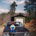 small boy sitting on old car