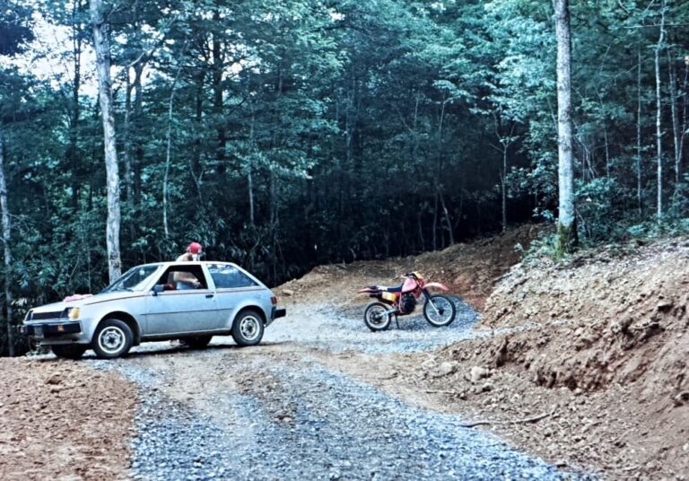 gray car motorcycle and man