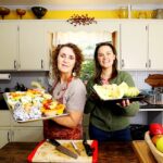women holding trays of vegetables